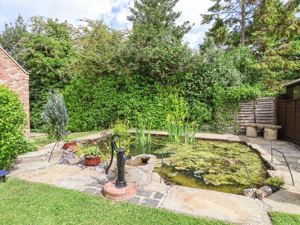 A garden with a pond and a pump at Croft Granary in Stillington near Easingwold and York