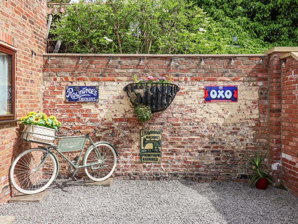 An outdoor area with a bicycle and vintage signs at Croft Granary Stillington near Easingwold and York