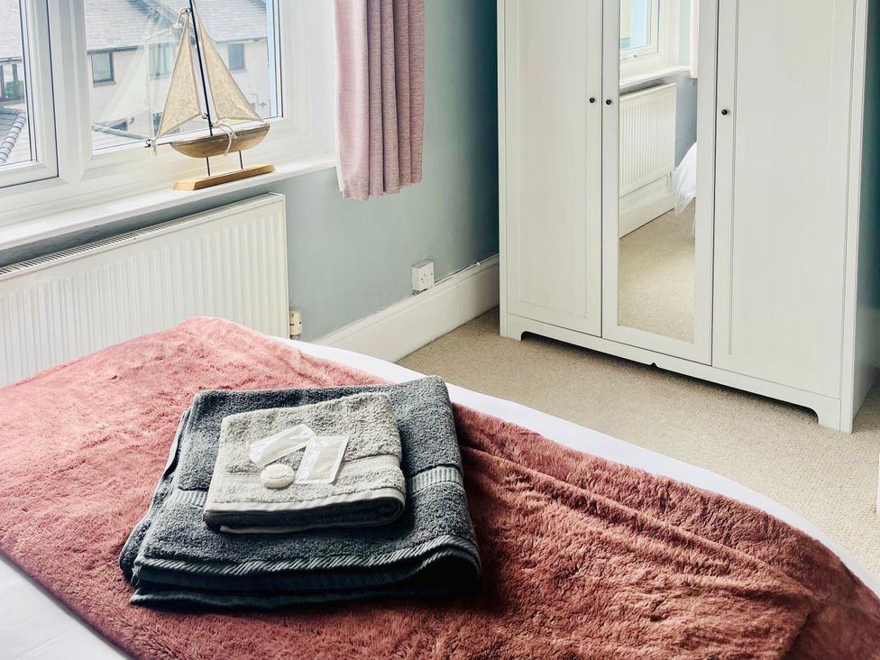 A bedroom with a bed and towels on a blanket at Corvette in Trearddur Bay