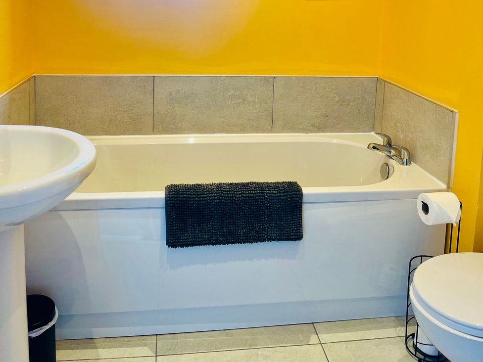 A bathroom with a bathtub, a sink, and a toilet at Corvette in Trearddur Bay