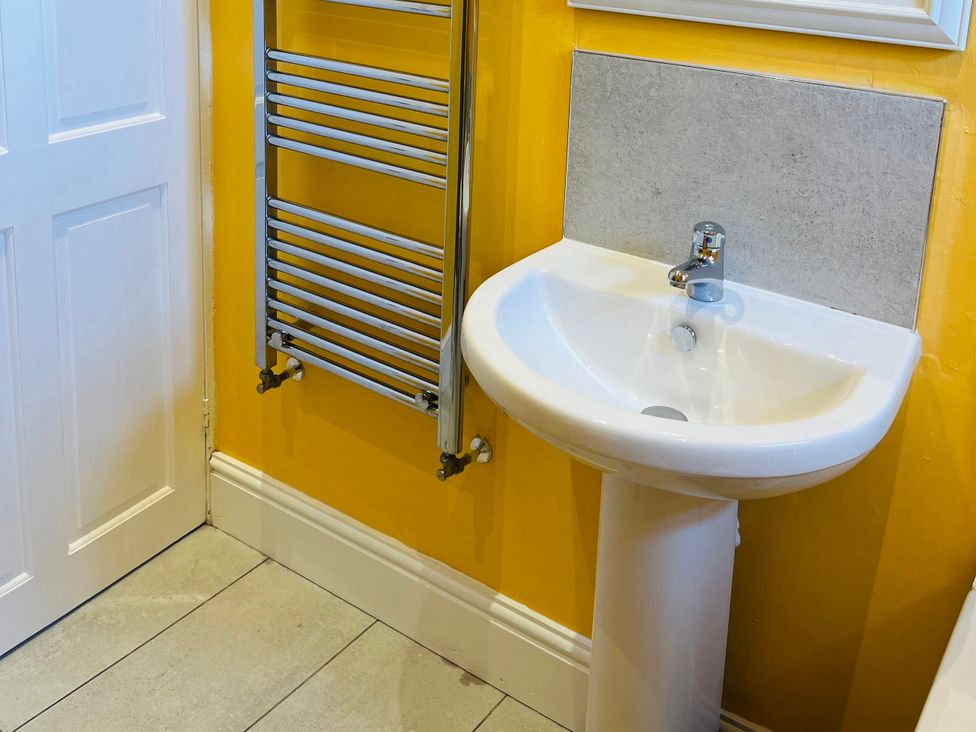 A bathroom with a sink and radiator at Corvette in Trearddur Bay