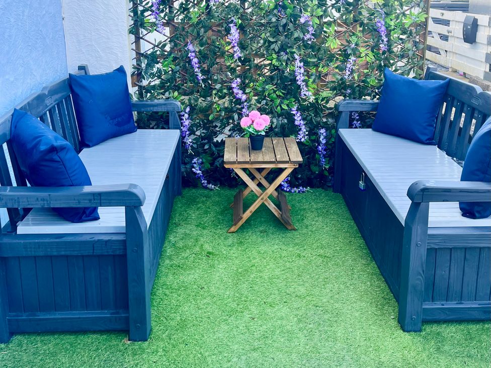 An outdoor seating area with sofas and table at Corvette in Trearddur Bay