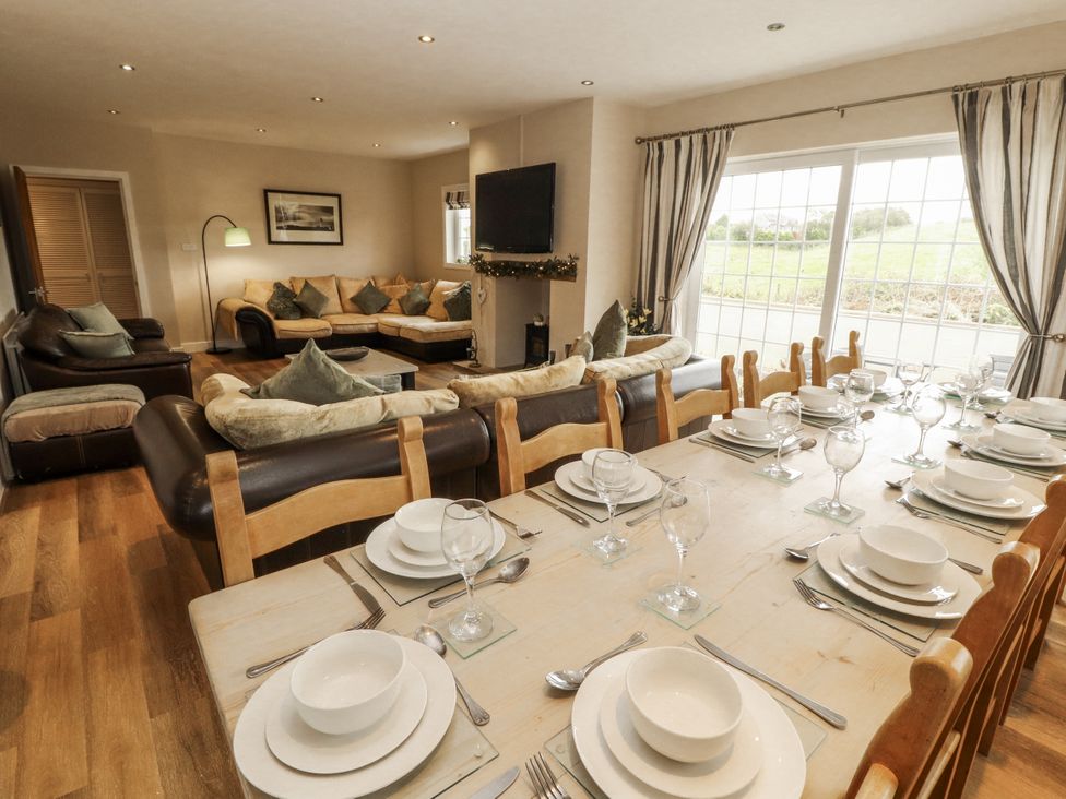 A dining room with a table set for a meal at White Gables in Great Clifton near Cockermouth