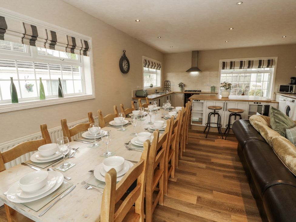 A dining room with a long table set for a meal at White Gables near Cockermouth