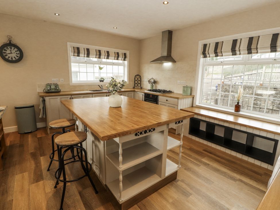 A kitchen with a sink and cooking stove at White Gables in Great Clifton near Cockermouth