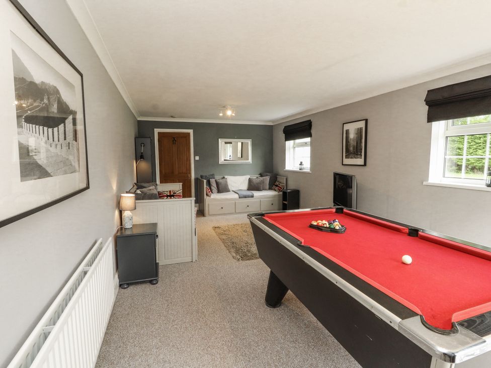 A snug with a pool table and a sofa at White Gables in Great Clifton near Cockermouth