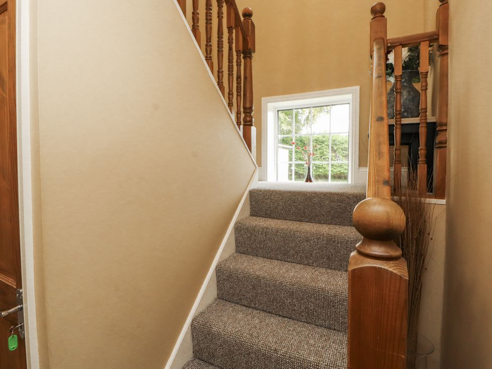 A staircase with a window and railing at White Gables in Great Clifton near Cockermouth