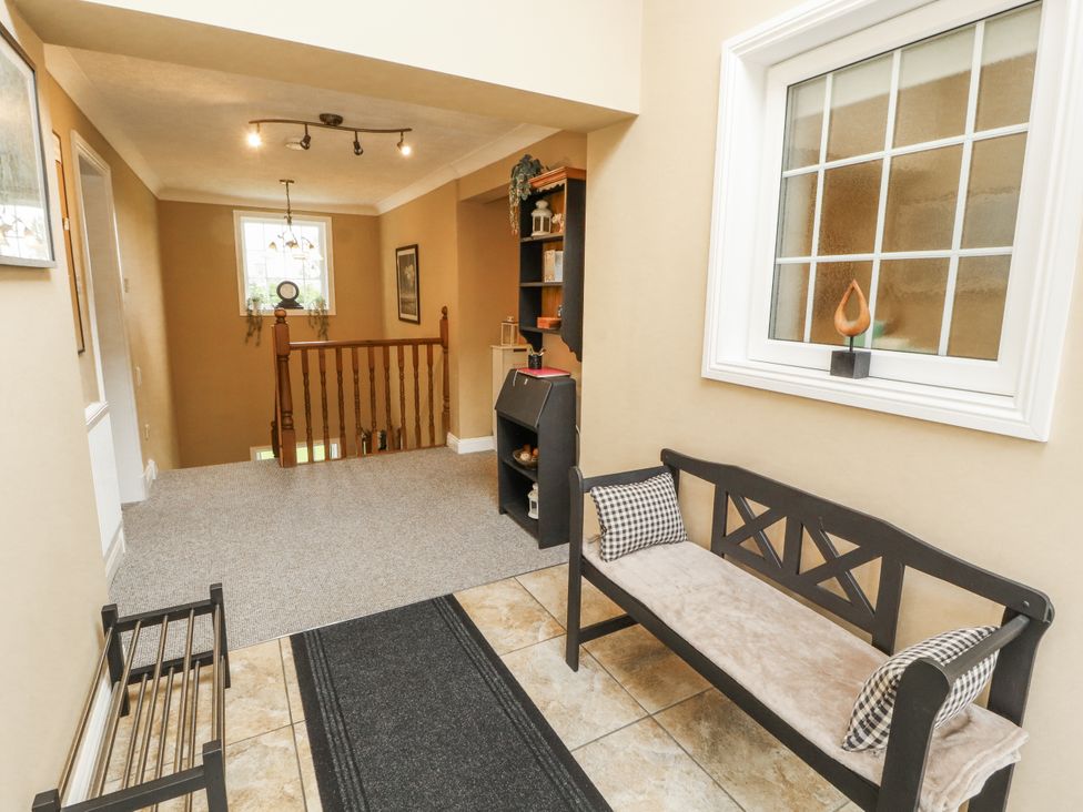 A hallway with a bench and staircase at White Gables in Great Clifton near Cockermouth
