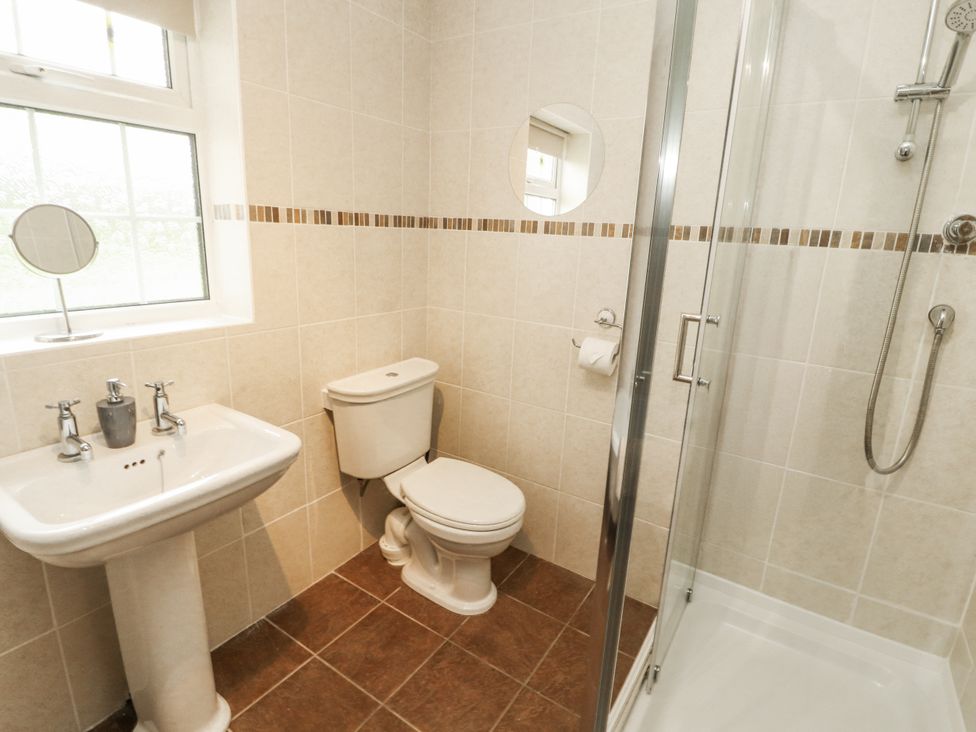 A bathroom with a shower, sink, and toilet at White Gables in Great Clifton near Cockermouth