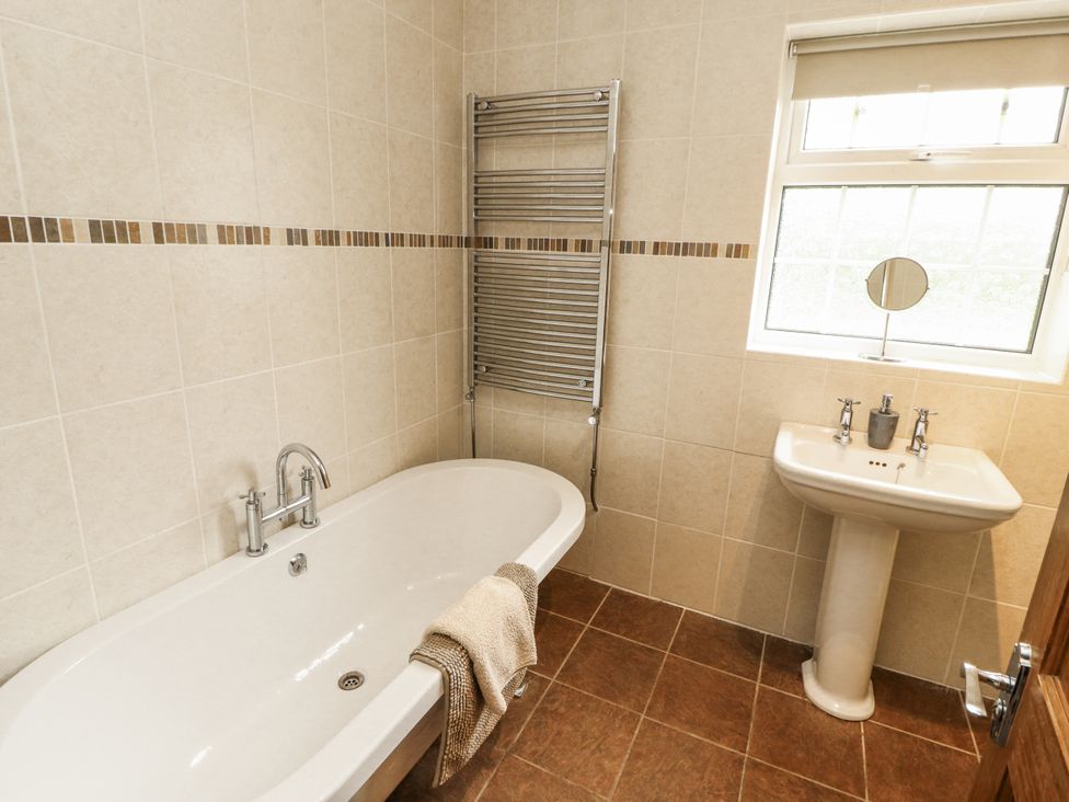 A bathroom with a bathtub and sink at White Gables in Great Clifton near Cockermouth