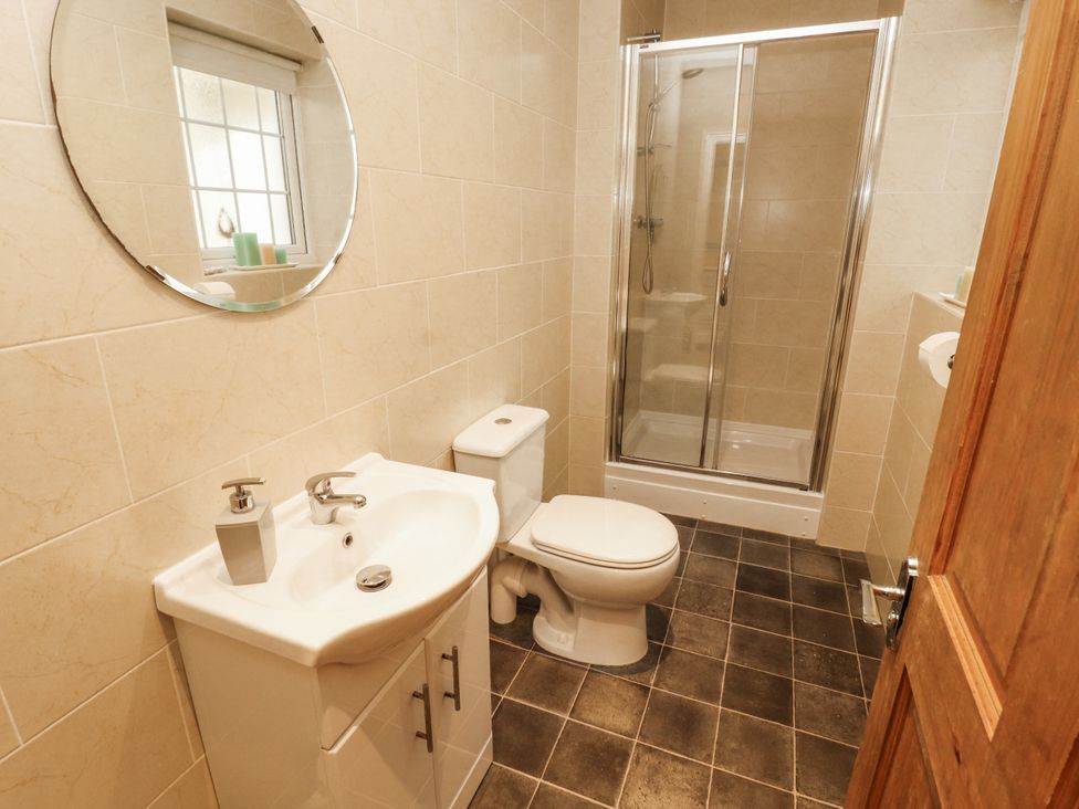 A bathroom with a sink, toilet, and shower at White Gables in Great Clifton near Cockermouth