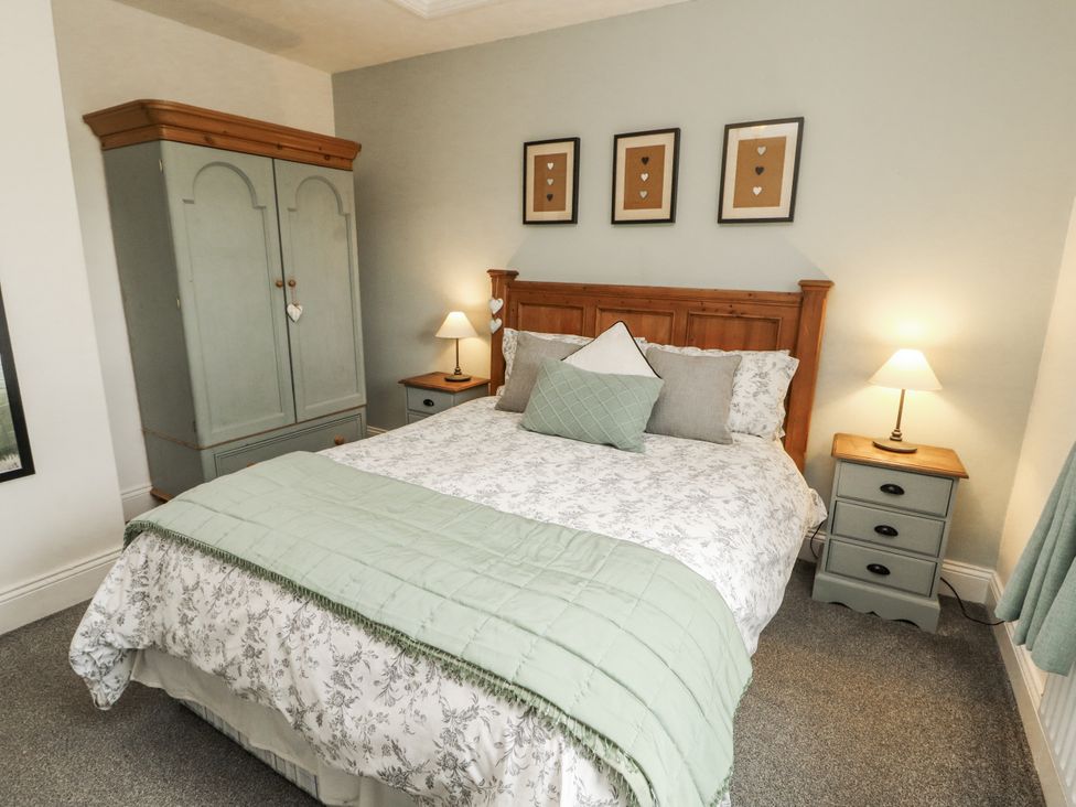 A bedroom with a bed and wardrobe at White Gables Great Clifton near Cockermouth