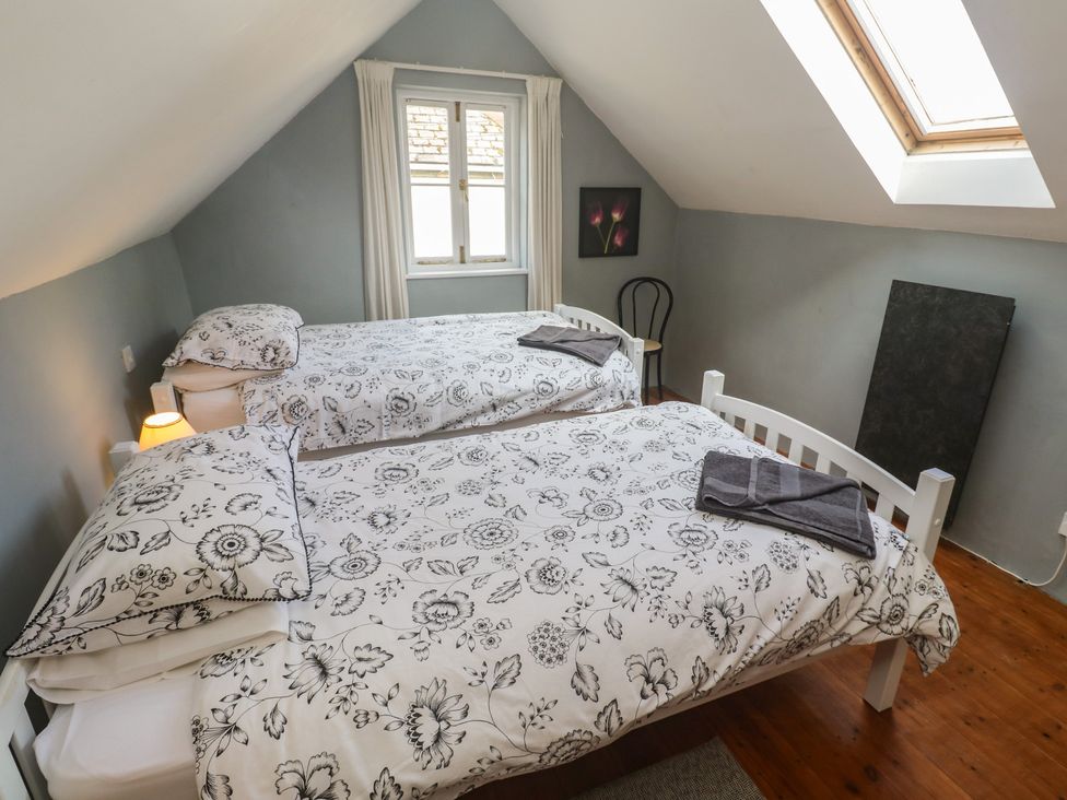 A bedroom with two beds and a window at Longhouse in St Keverne, Lizard Peninsula