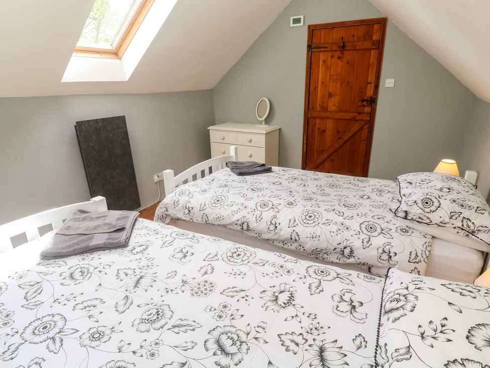 A bedroom with two beds and a dresser at Longhouse in St Keverne, Lizard Peninsula