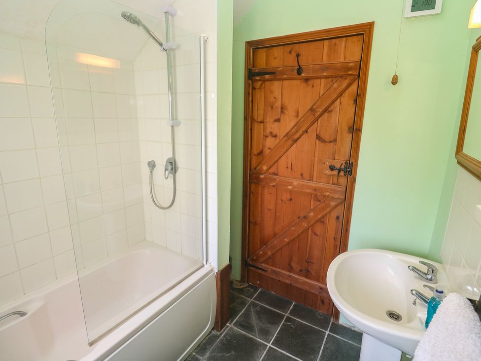 A bathroom with a bathtub and shower at Longhouse St Keverne, Lizard Peninsula