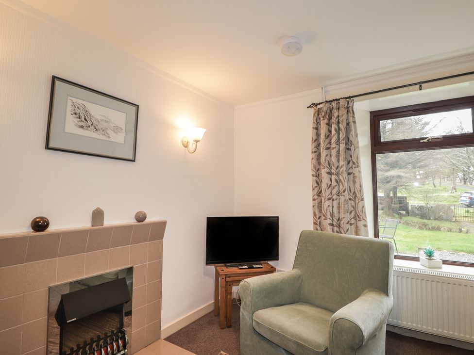 A living room with a chair and television at Lag-Uaine in Staffin