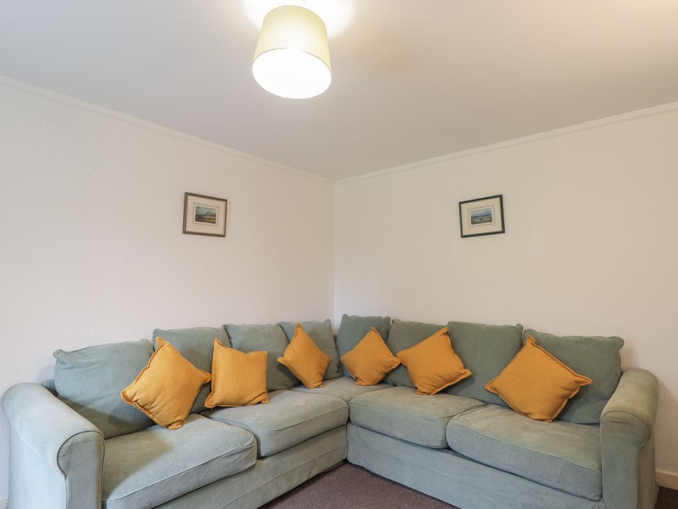 A living room with a sectional sofa and framed picture at Lag-Uaine in Staffin