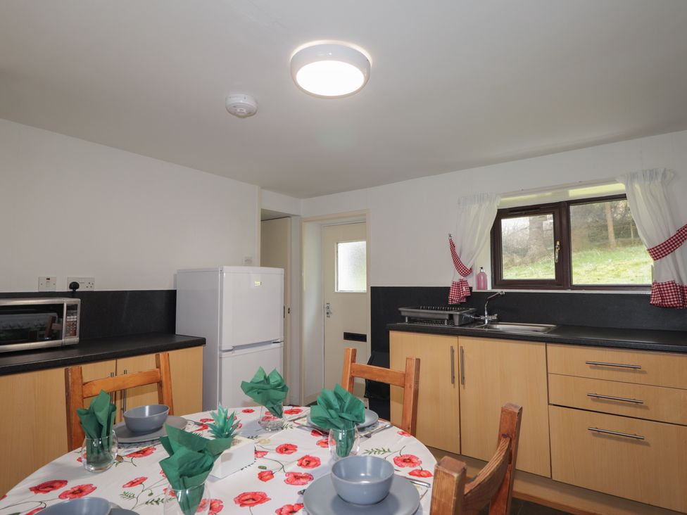 A kitchen with appliances and dining table at Lag-Uaine in Staffin