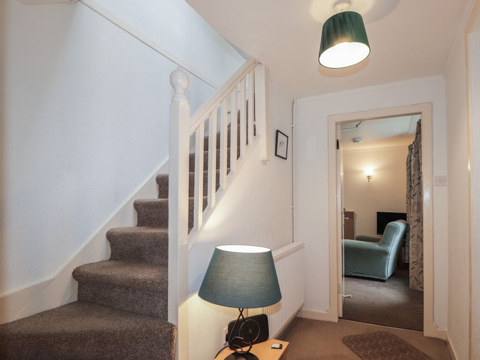 A hallway with stairs and a lamp at Lag-Uaine in Staffin