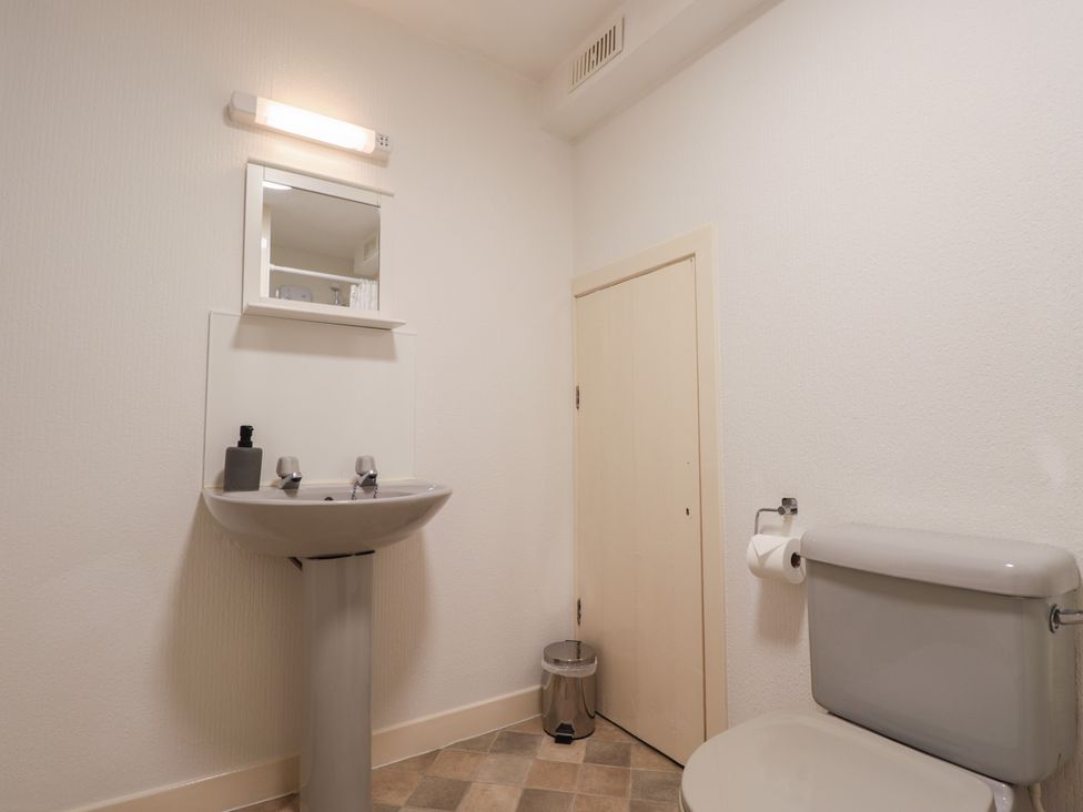 A bathroom with a sink, toilet, and mirror at Lag-Uaine in Staffin