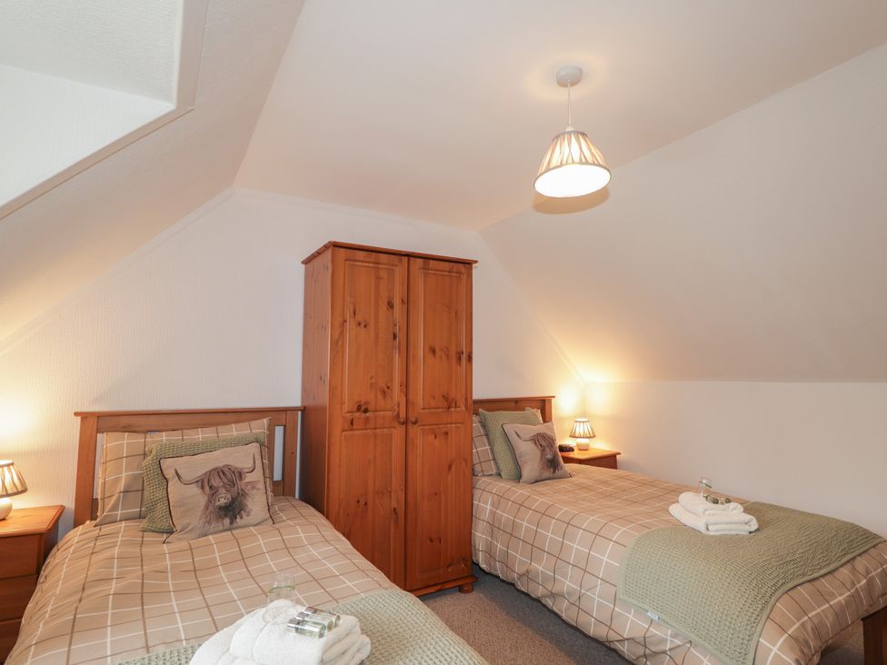 A bedroom with twin beds and a wardrobe at Lag-Uaine in Staffin