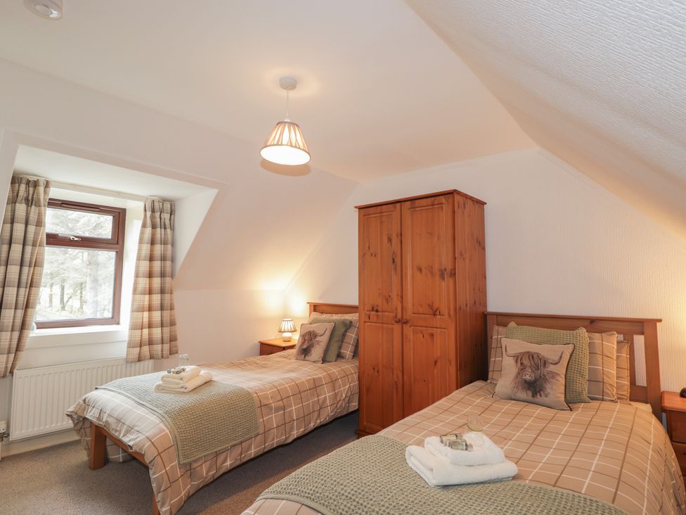 A bedroom with two beds and a wardrobe at Lag-Uaine in Staffin