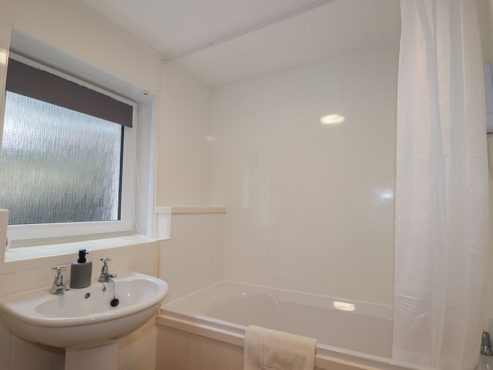 A bathroom with a bath tub and sink at Lag-Uaine in Staffin