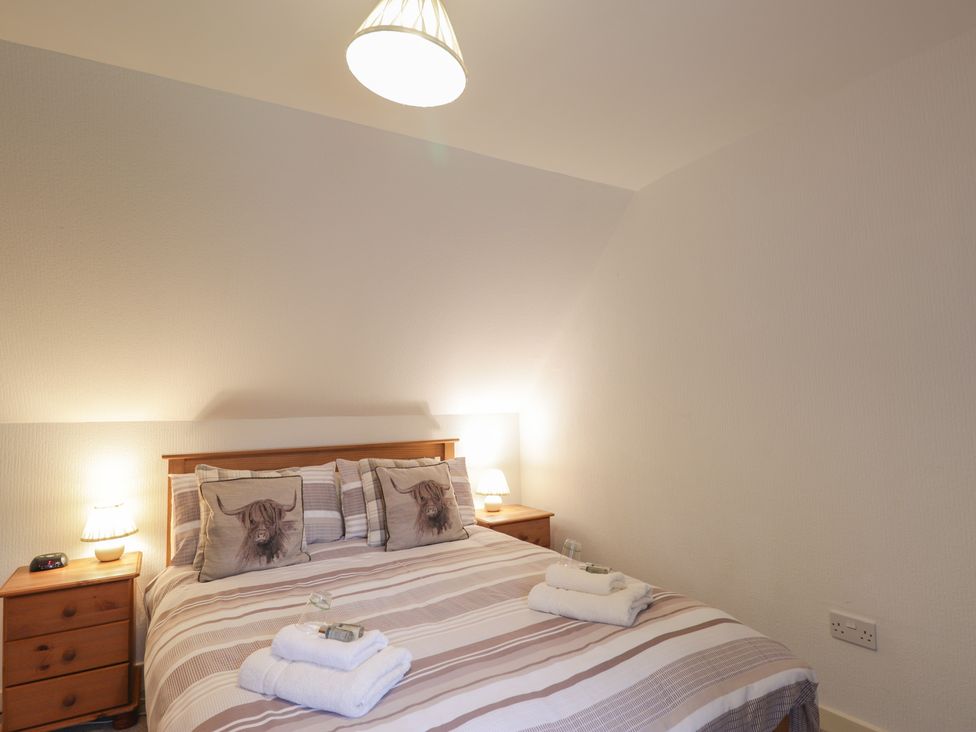 A bedroom with a bed and nightstand at Lag-Uaine in Staffin