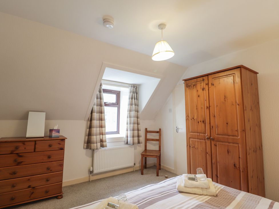 A bedroom with a bed, wardrobe, and chest of drawers at Lag-Uaine in Staffin