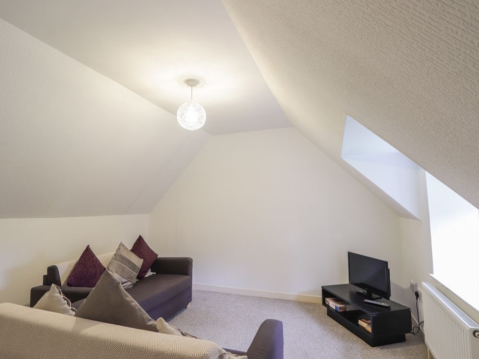 A living room with a sofa and a television at Lag-Uaine in Staffin