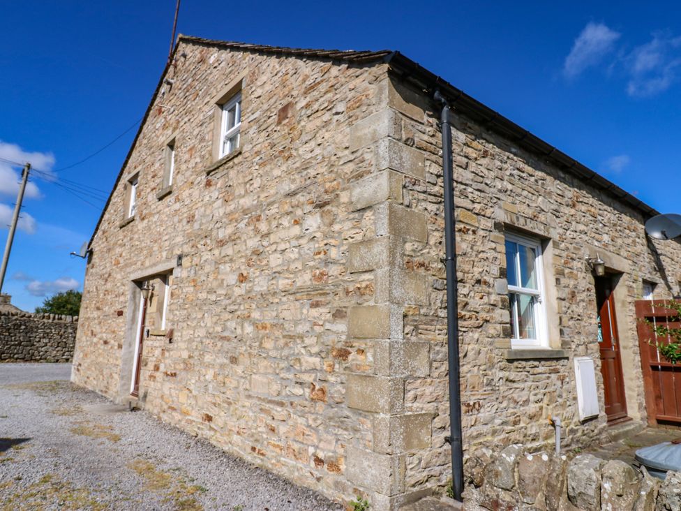 A stone house with windows and a door at Barnbrook in Carperby near Leyburn