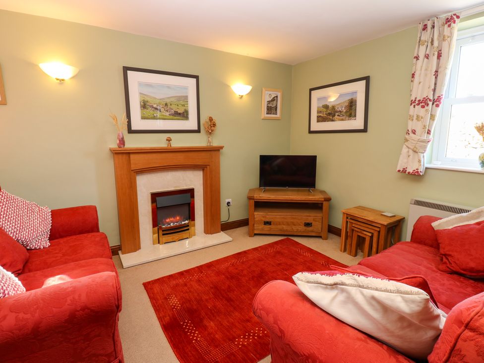 A living room with a television and fireplace at Barnbrook in Carperby near Leyburn