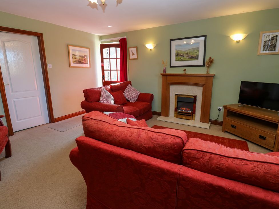 A living room with a sofa and television at Barnbrook Carperby near Leyburn