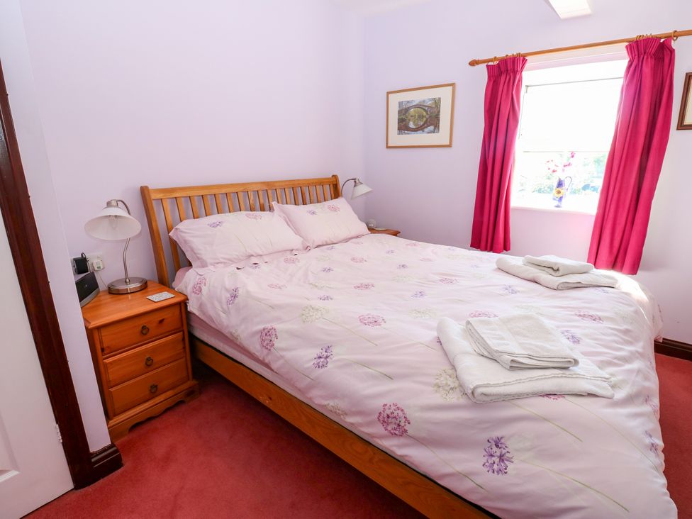 A bedroom with a bed and bedside table at Barnbrook in Carperby near Leyburn