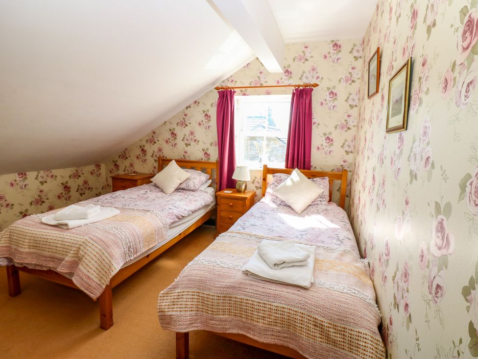 A bedroom with two single beds and a window at Barnbrook in Carperby near Leyburn