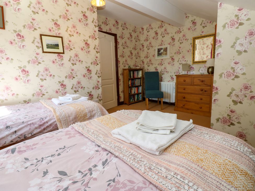 A bedroom with two beds and a dresser at Barnbrook in Carperby near Leyburn