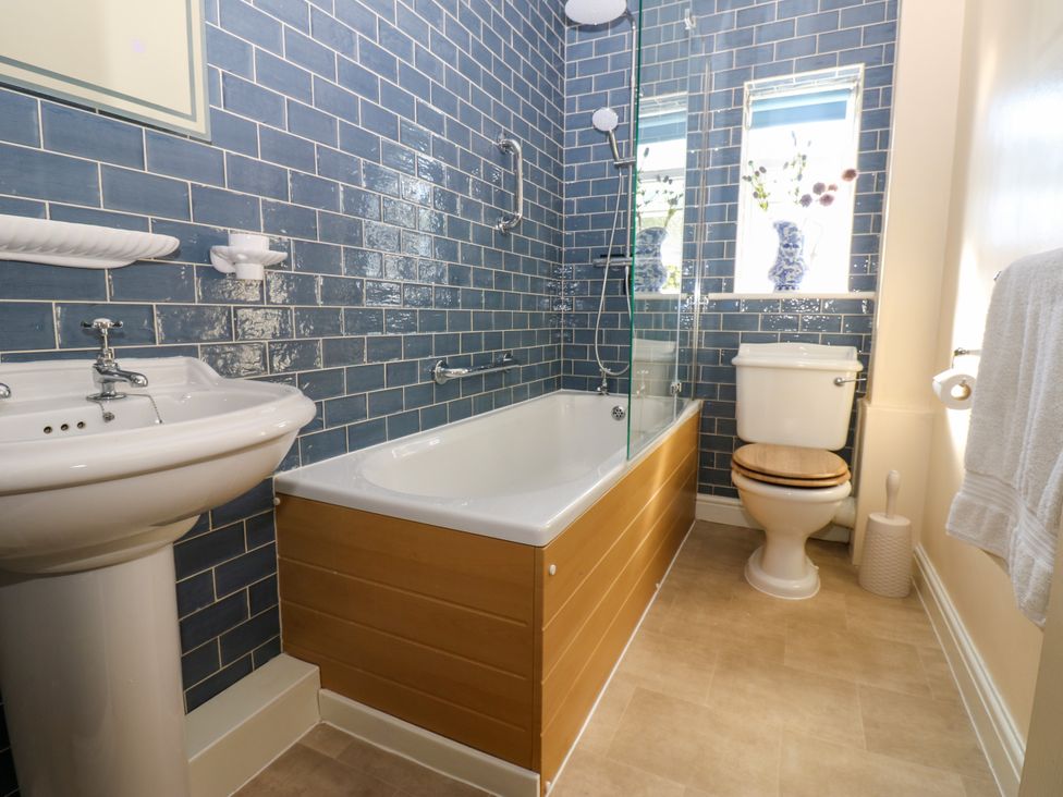 A bathroom with a bathtub, sink, and toilet at Barnbrook in Carperby near Leyburn