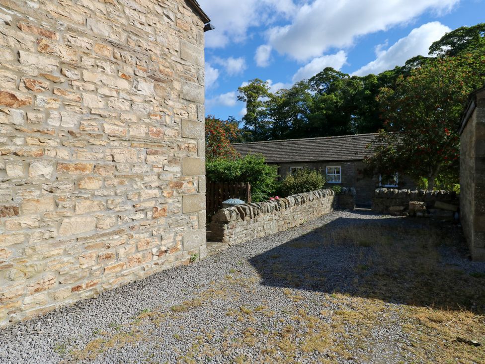An outdoor area with stone walls and gravel at Barnbrook Carperby near Leyburn