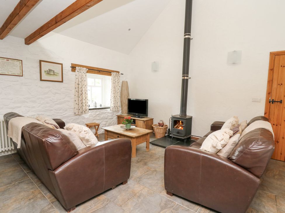 A living room with a fireplace and sofa at Bwthyn Bach in Newport