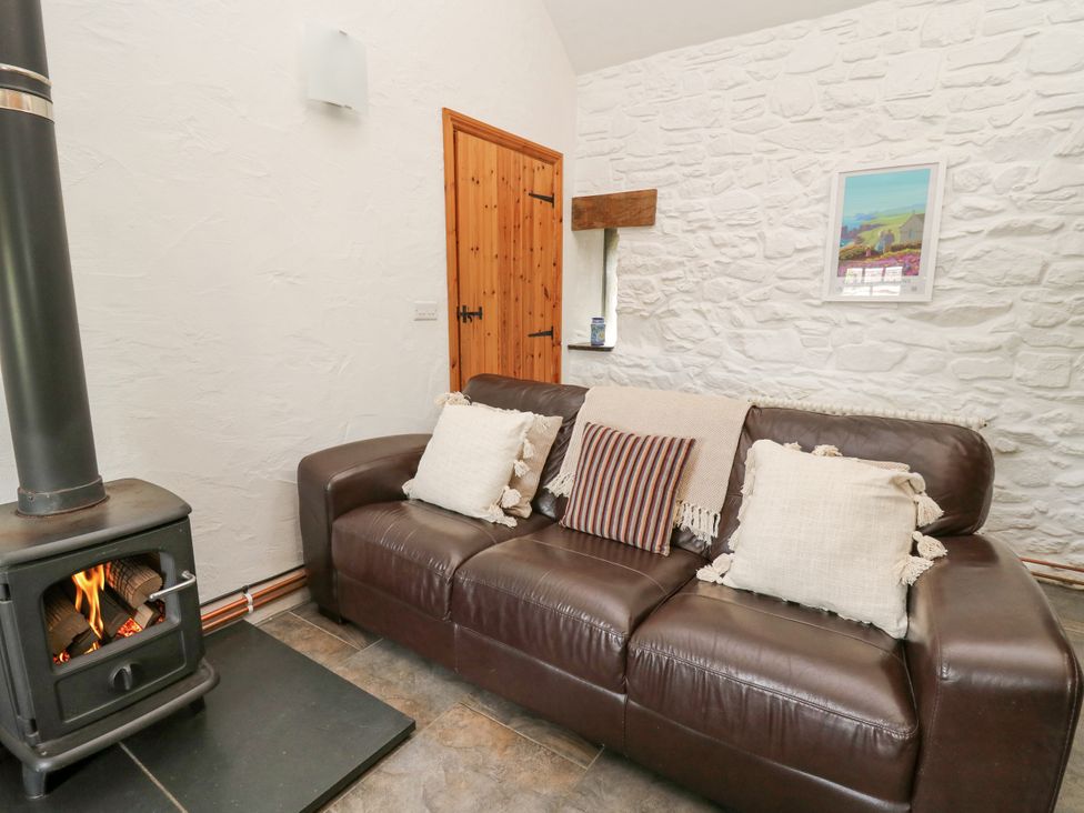 A living room with a sofa and a fireplace at Bwthyn Bach in Newport