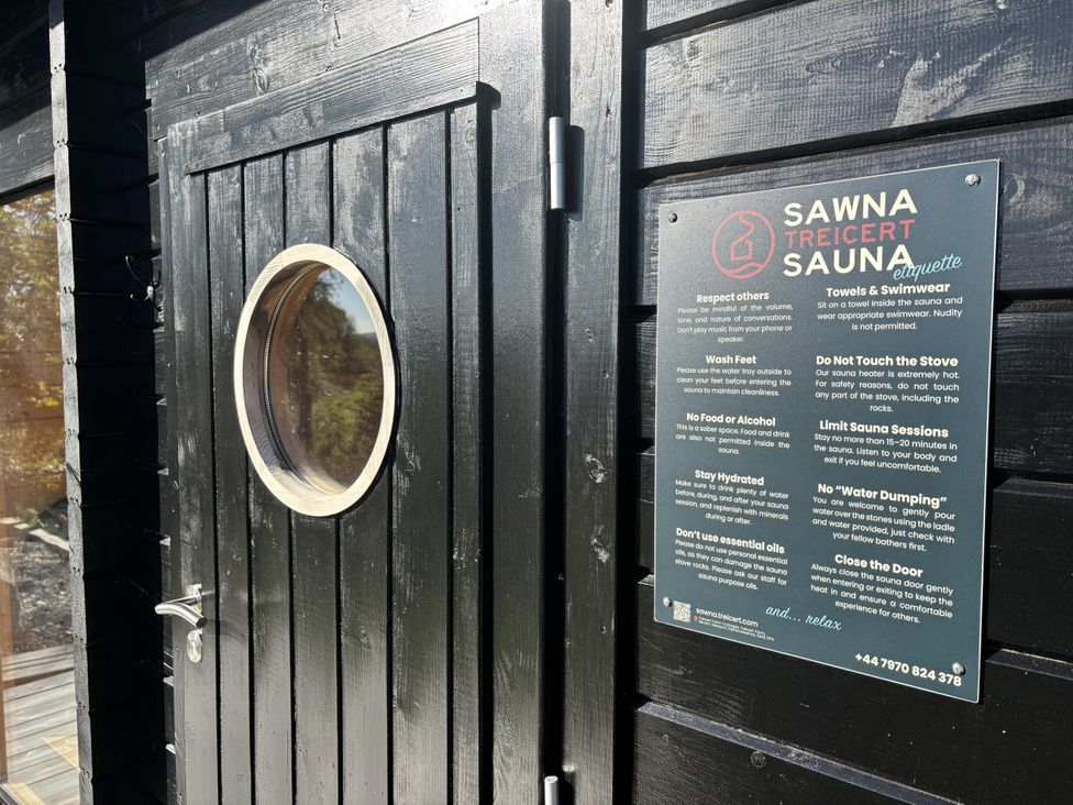 A sauna with a round window and etiquette sign at Treicerth Sauna in Newport