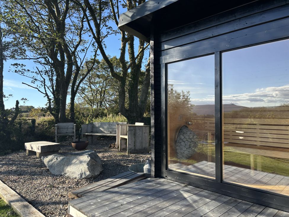 An outdoor seating area with stone fire pit at Y Cwtch Newport