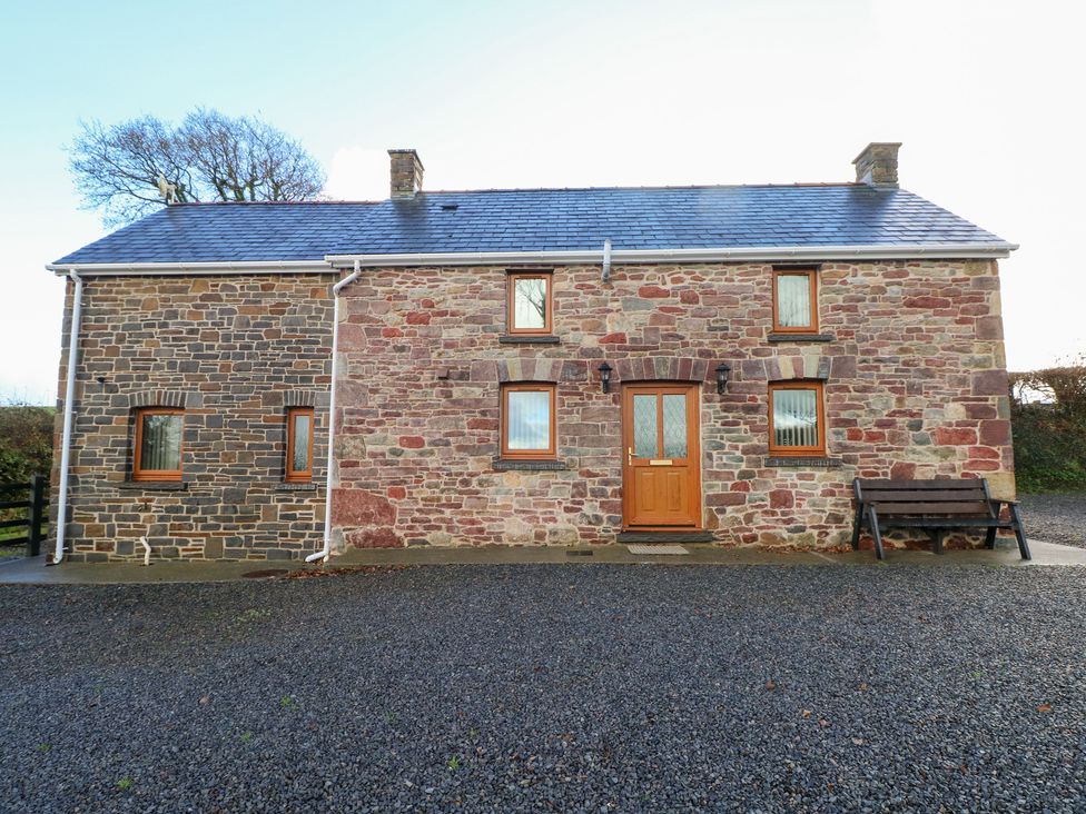 A house with stone walls and a front door at Bwthyn Trecoed St. Clears near Carmarthen