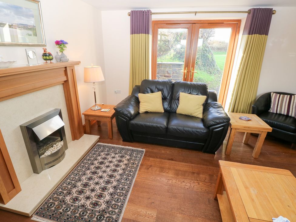 A living room with a sofa and coffee table at Bwthyn Trecoed near St. Clears