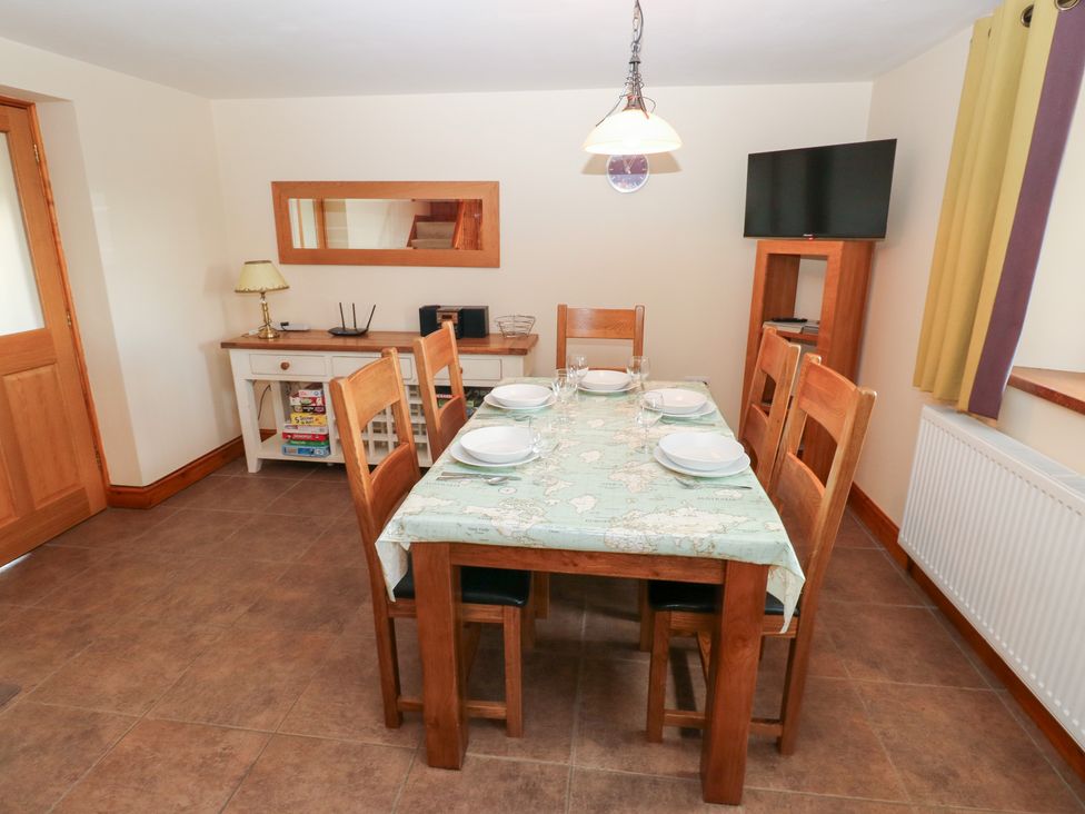 A dining room with a table and chairs at Bwthyn Trecoed in St. Clears near Carmarthen