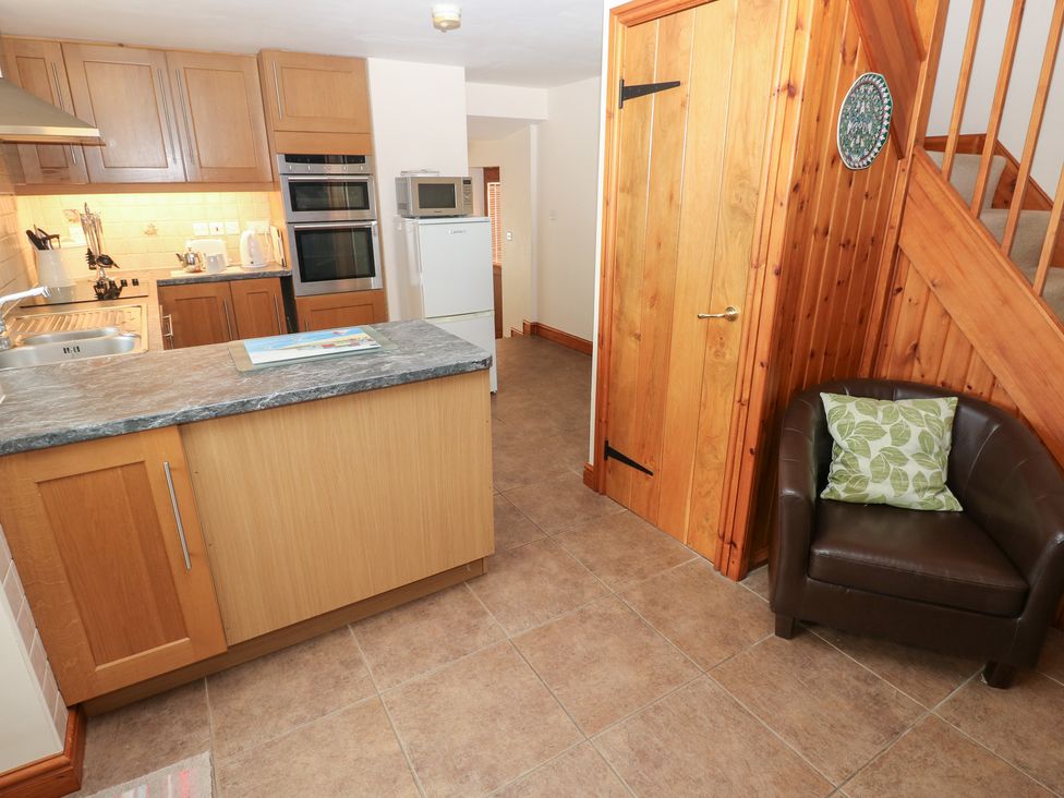 A kitchen with cabinets and appliances at Bwthyn Trecoed in St. Clears near Carmarthen