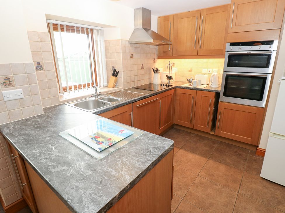 A kitchen with cabinets and a sink at Bwthyn Trecoed in St. Clears near Carmarthen