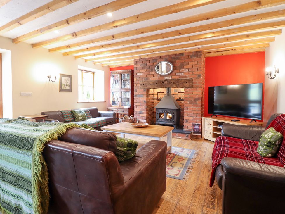 A living room with a fireplace and sofas at Ysgubor Pwlliago in Pennant Valley near Llangynog