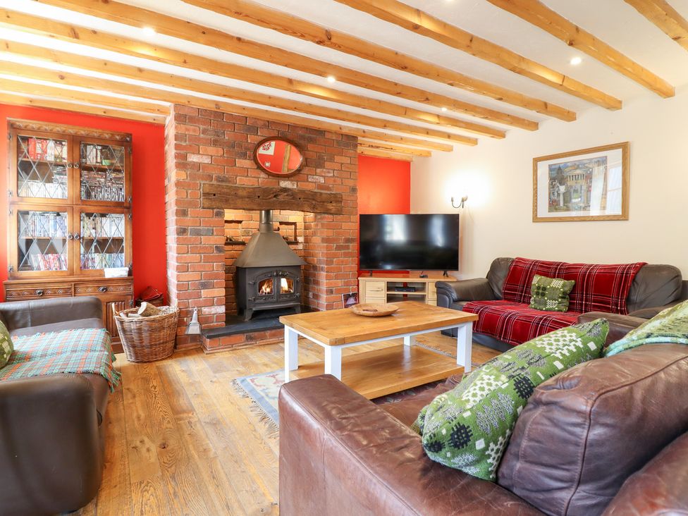 A living room with a fireplace, television, and furniture at Ysgubor Pwlliago in Pennant Valley near Llangynog