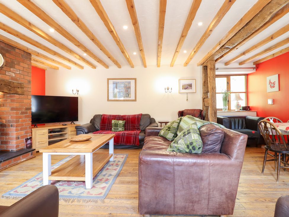 A living room with a sofa, TV, and coffee table at Ysgubor Pwlliago, Pennant Valley near Llangynog